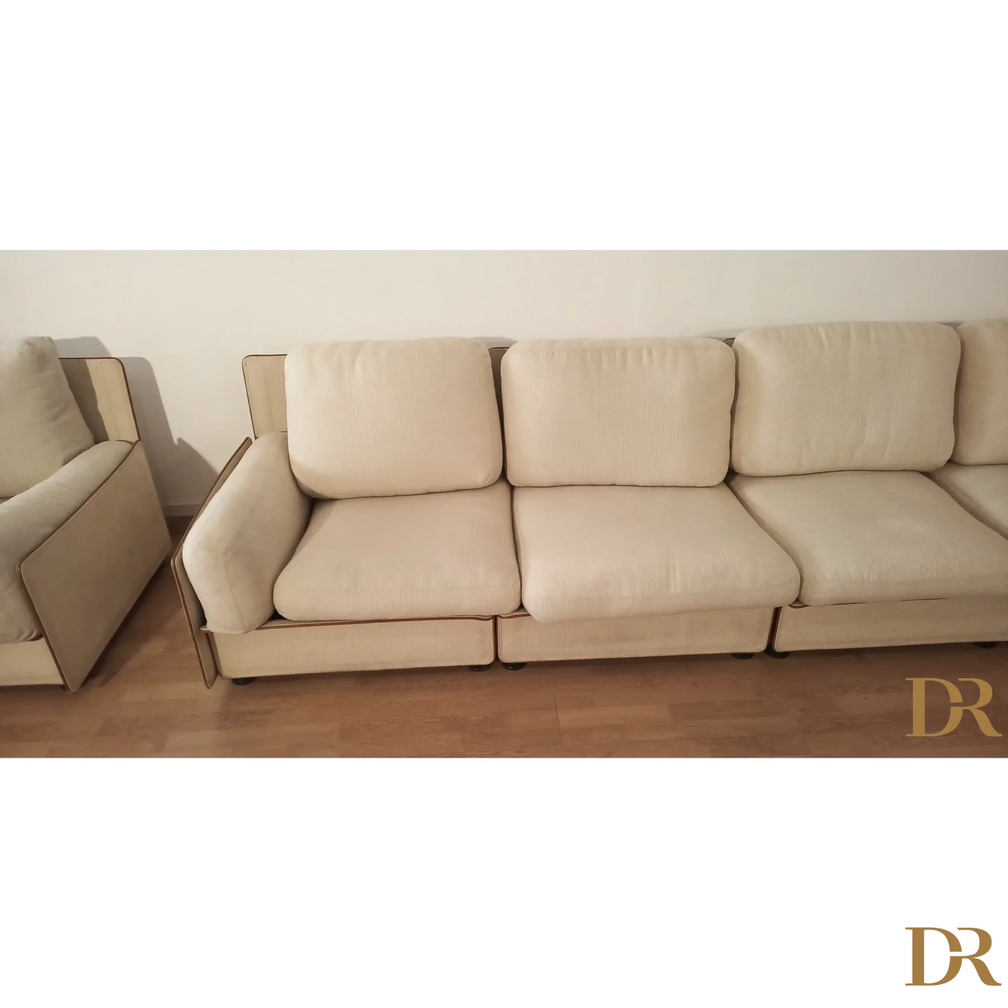 Divano modulare di Riccardo Arbizzoni con tre cuscini color crema e design elegante