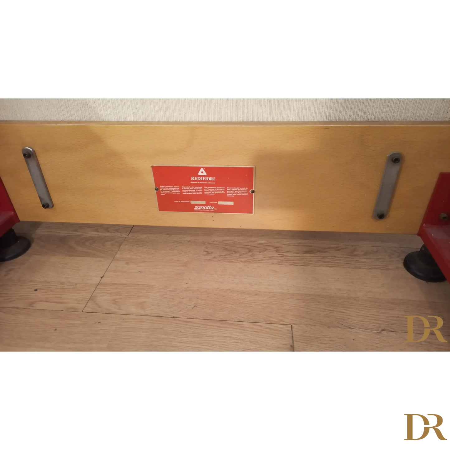 Etichetta di avviso rossa su pannello beige del Divano Riccardo Arbizzoni 1978