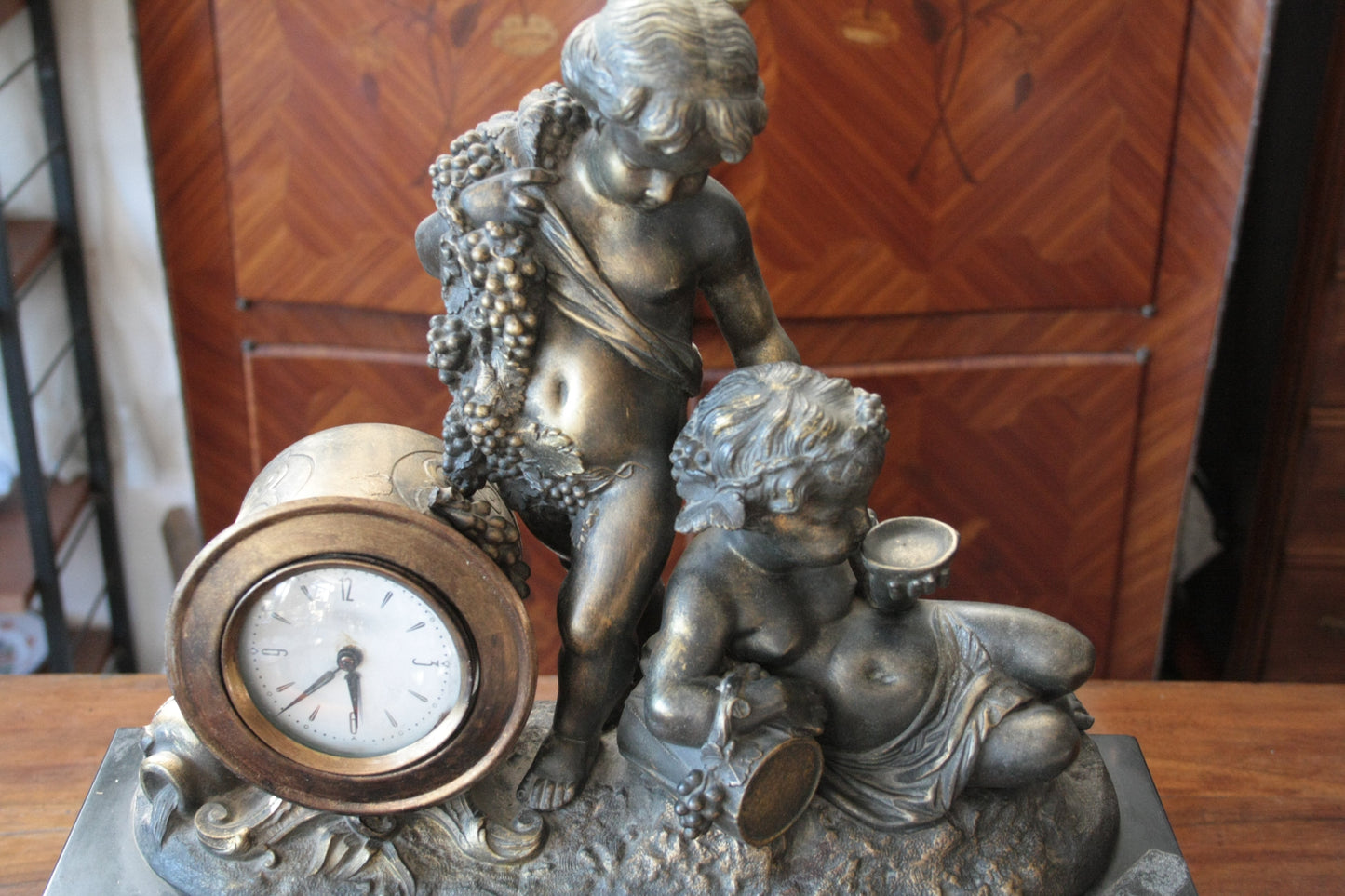 Orologio Napoleone III in bronzo e marmo con cherubino e motivi di uva, XIX secolo