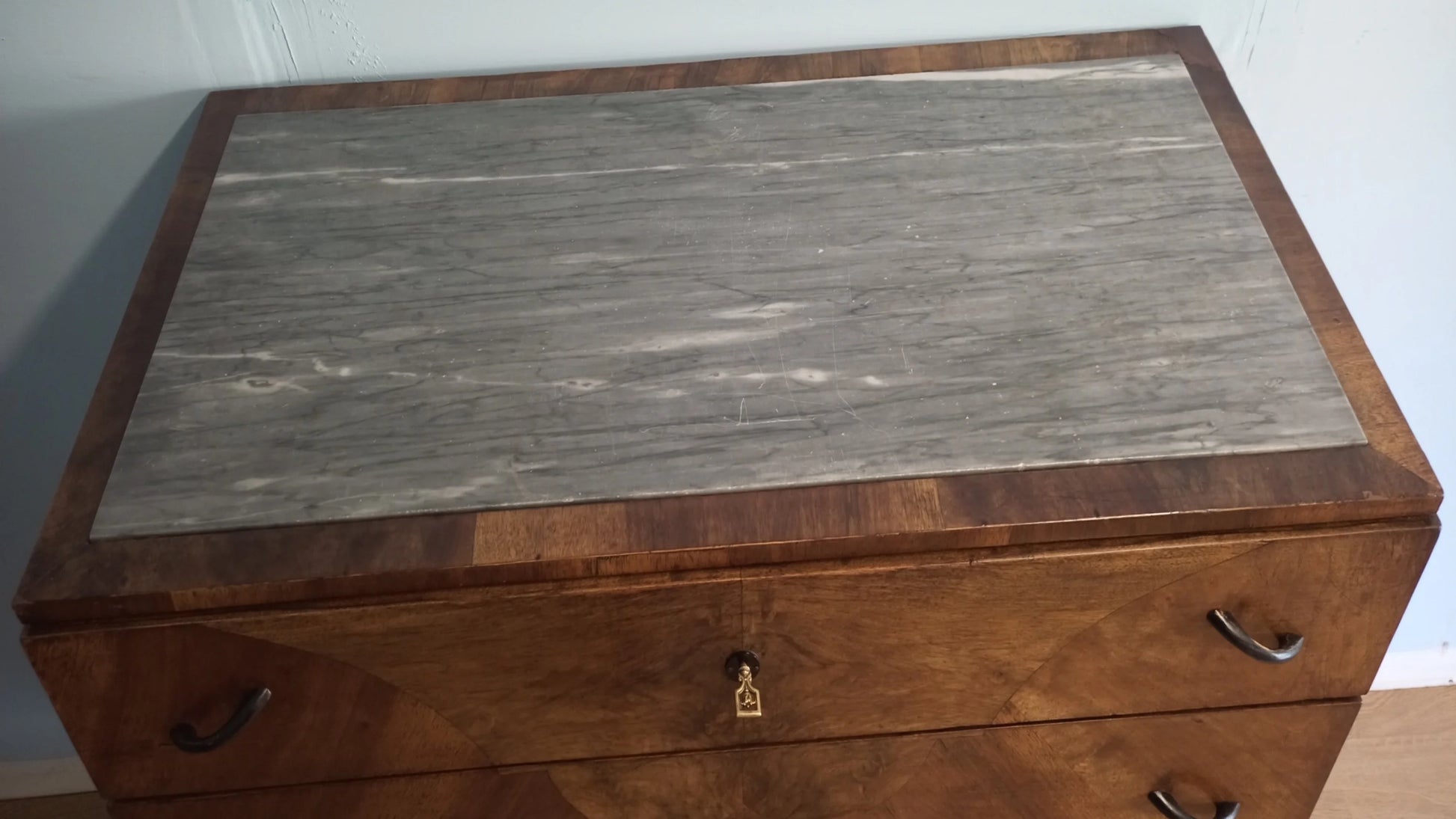 Cassettiera legno vintage in camera letto con piano in marmo grigio e pomelli sui cassetti in legno