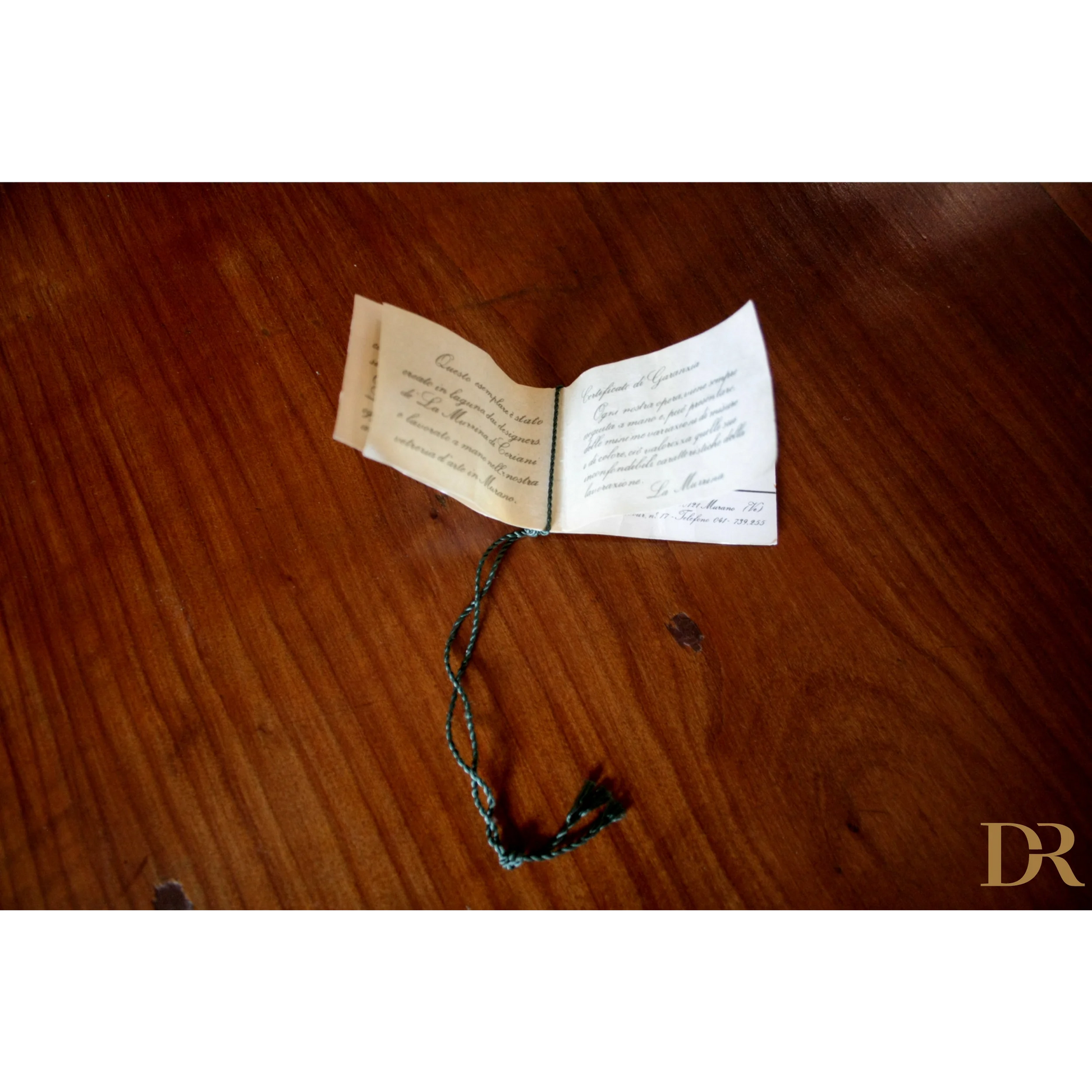 Libro aperto a mano con stringa decorativa, design italiano e vetro soffiato casa