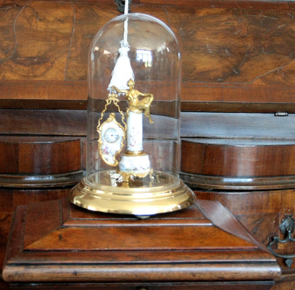 Orologio da tavolo in bronzo e smalti art decò con figura femminile e scena galanti su base xix secolo sotto cupola di vetro