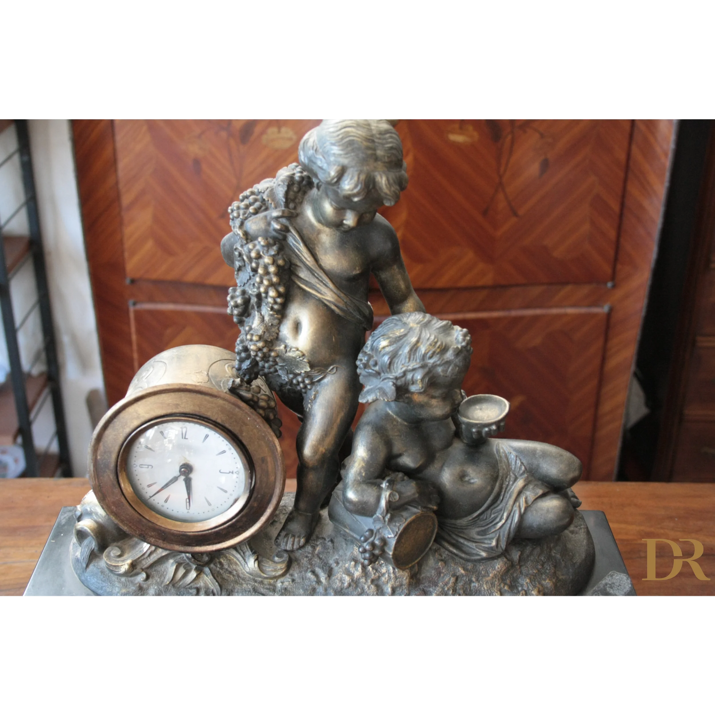 Orologio Napoleone III in bronzo e marmo con cherubino e motivi di uva, XIX secolo