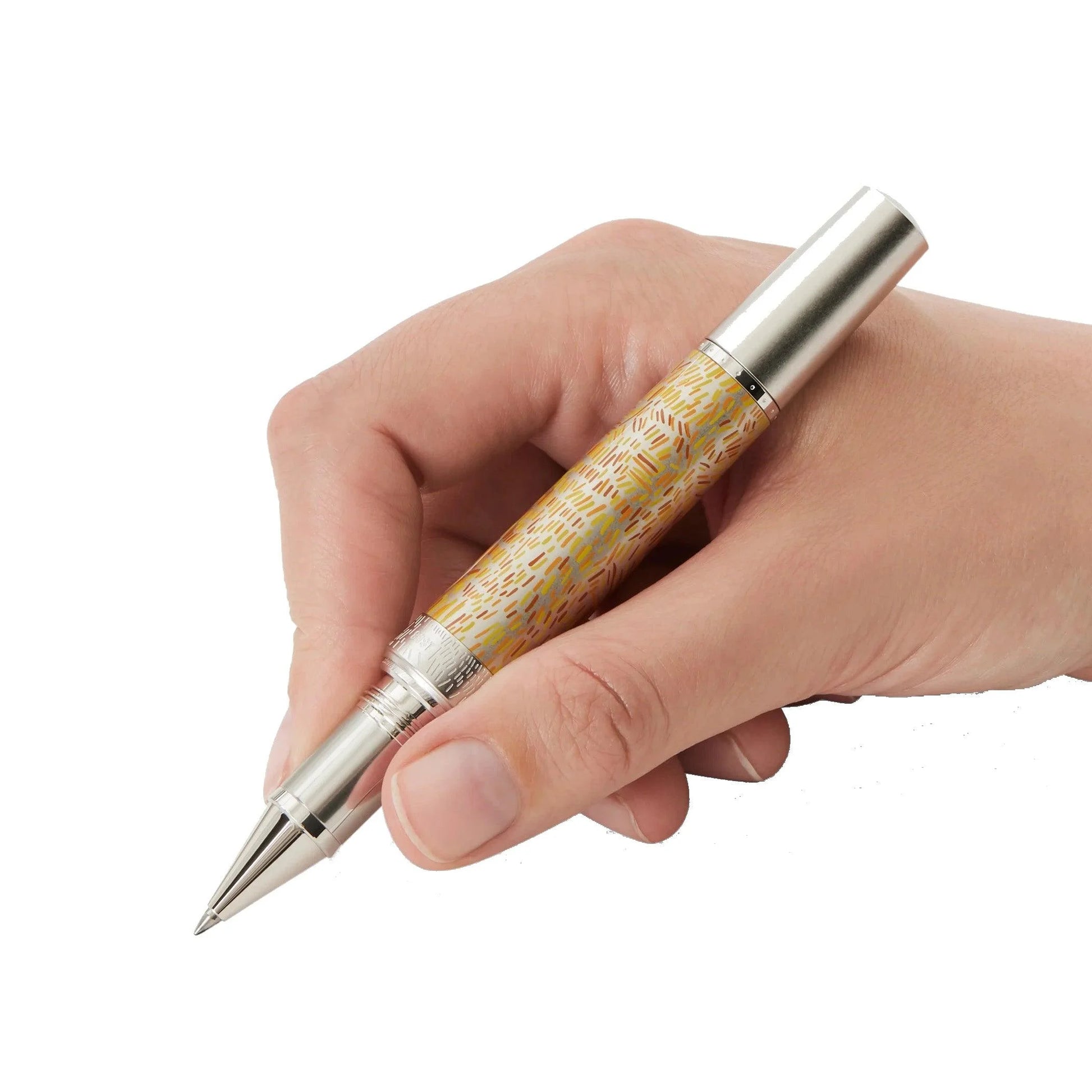 Una mano che tiene una penna rollerball montblanc roller masters of art omaggio a vincent van gogh con corpo legno dorato e dettagli argento lucido