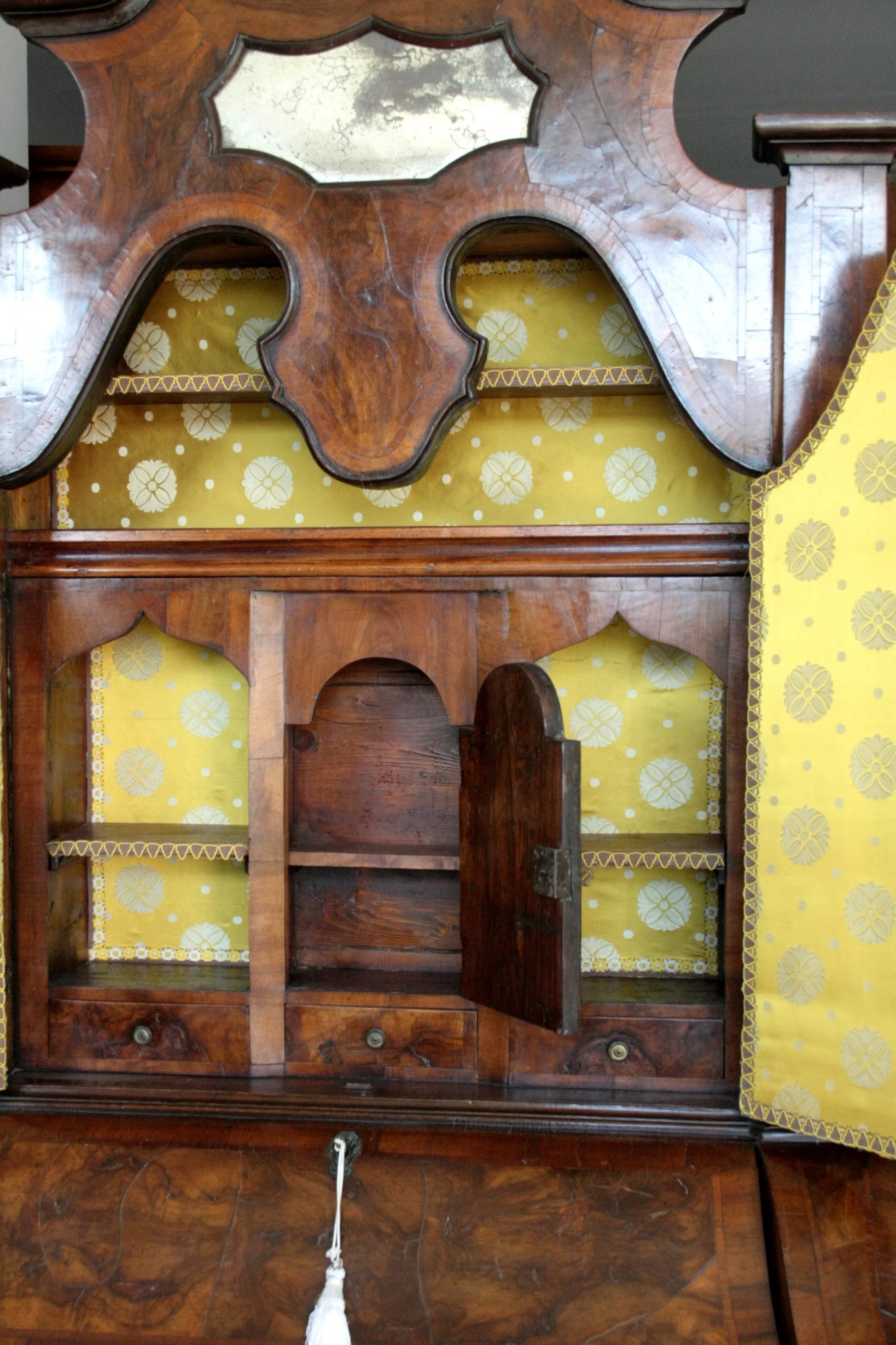 Antico trumeau lombardo originale in noce con linea trapezoidale elegante e corpo mosso presenta rivestimento giallo decorato