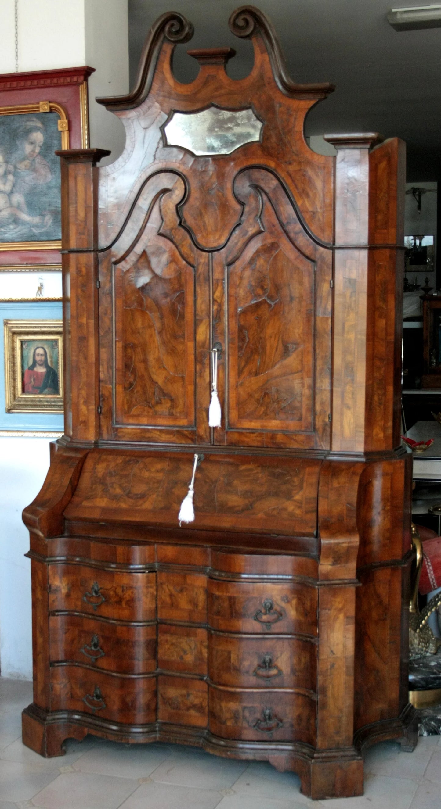 Trumeau lombardo originale in noce e radica con linea trapezoidale elegante e corpo mosso presenta dettagli scolpiti e specchio