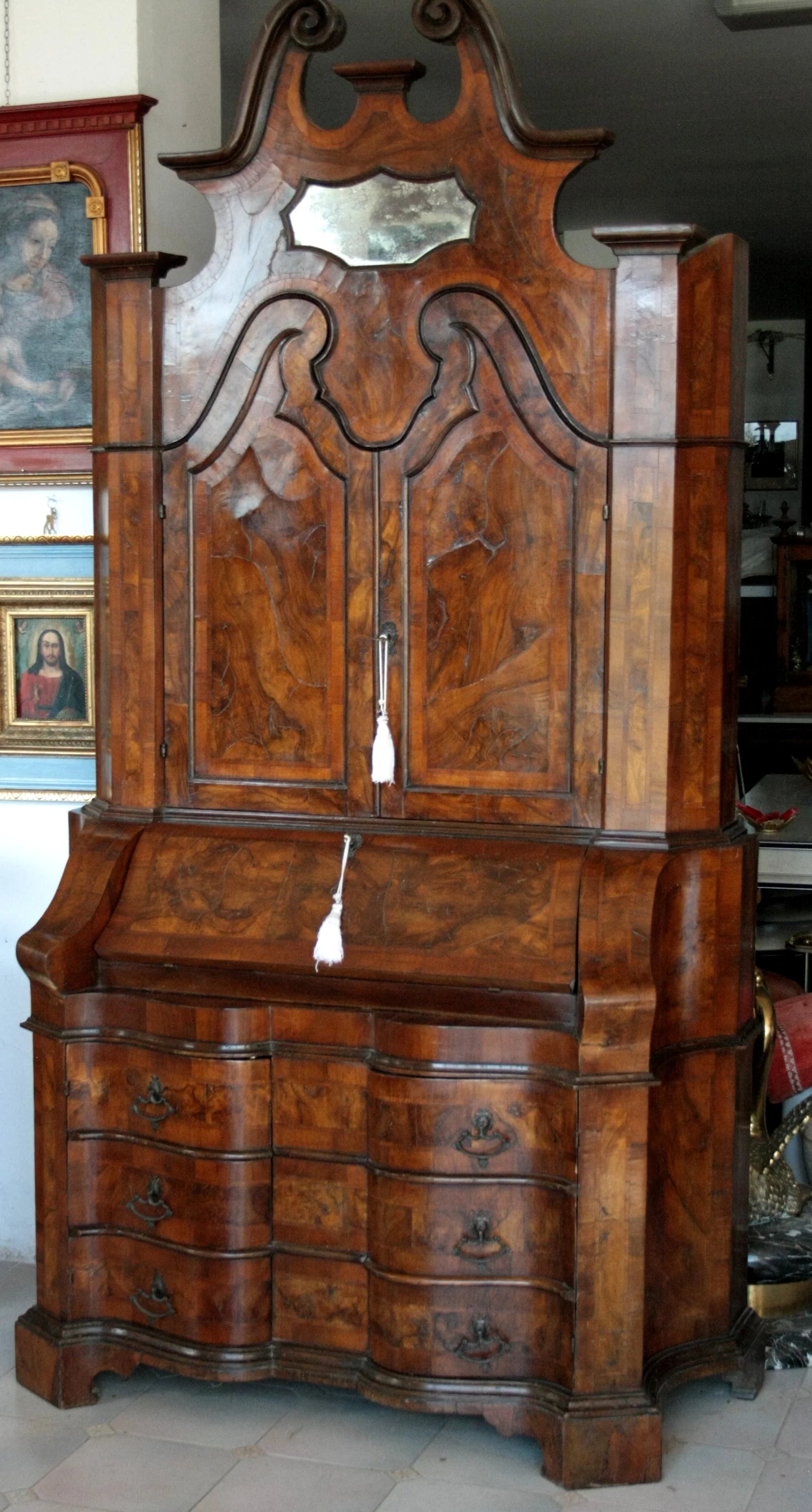 Trumeau lombardo originale in noce e radica di noce con linea trapezoidale elegante e corpo mosso presenta multipli cassetti e specchio