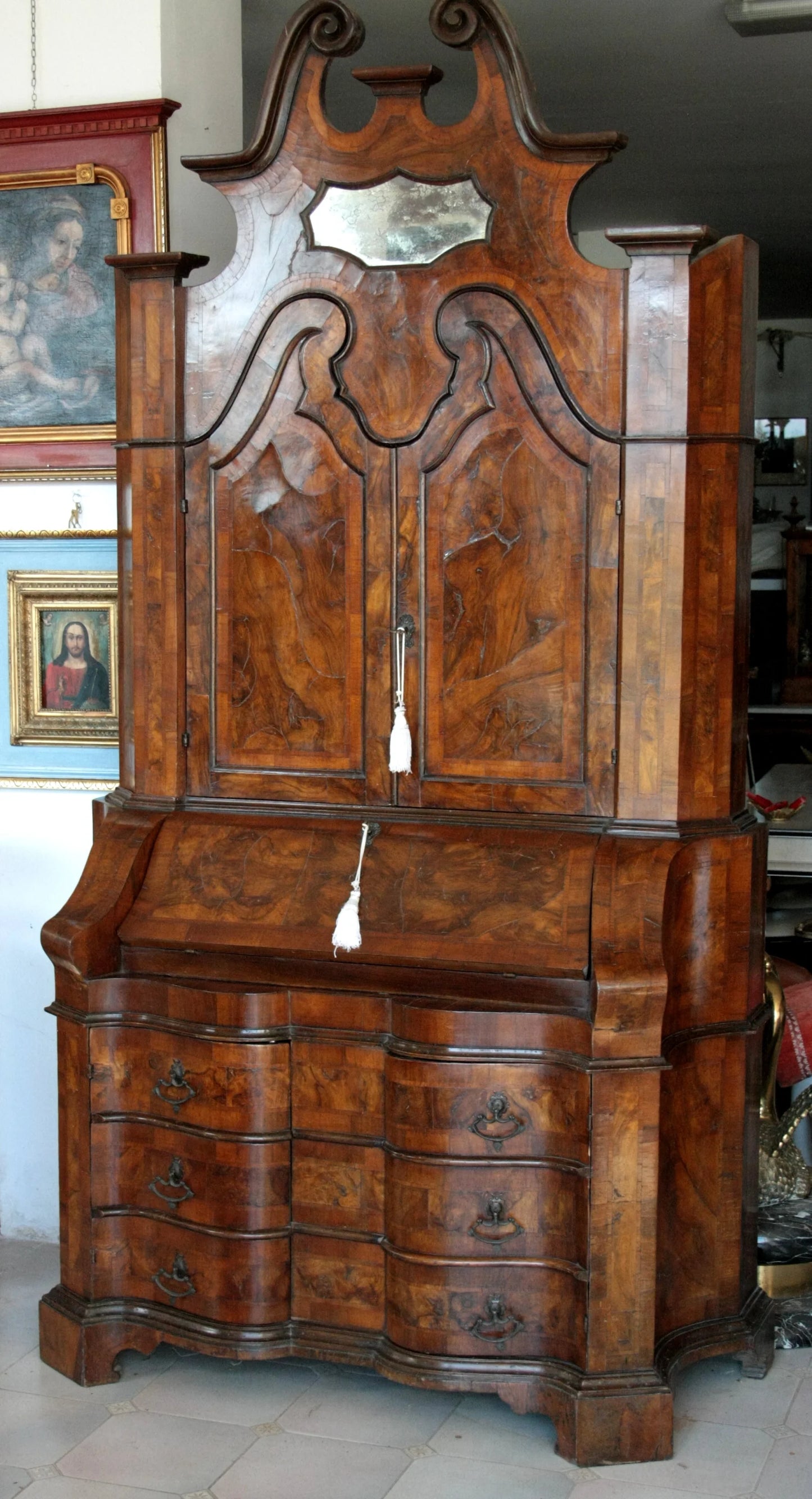 Trumeau lombardo originale in noce con linea trapezoidale elegante e corpo mosso presenta specchio e cassetti multipli