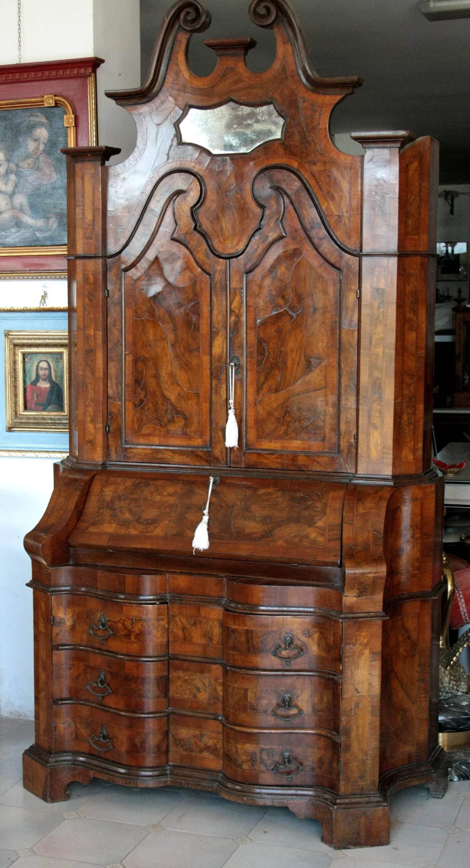 Trumeau lombardo originale in noce con linea trapezoidale elegante e corpo mosso presenta specchio e cassetti multipli