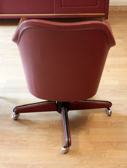 Sedia girevole color marsala nel set studio umberto mascagni con scrivania ministeriale disegnata italia 1950
