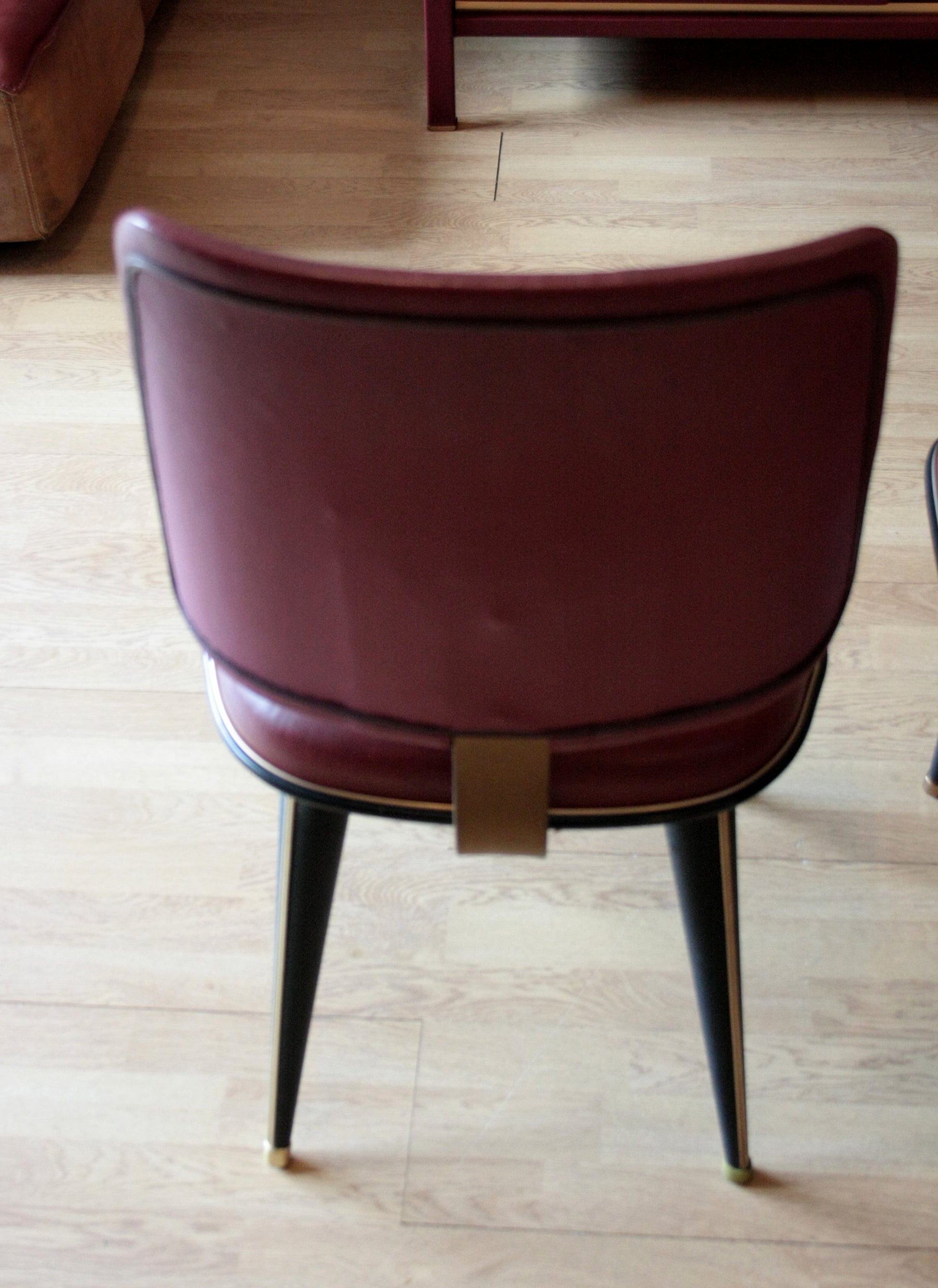 Sedia in similpelle bordeaux con gambe nere nel set studio Umberto Mascagni Italia 1950