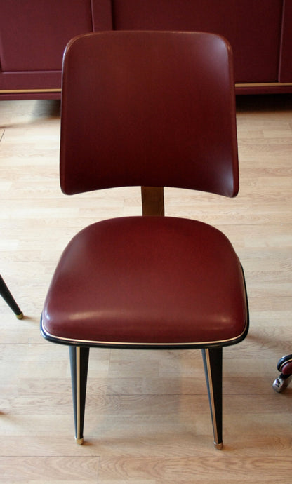 Sedie in similpelle bordeaux con gambe nere e dorate nel set studio Umberto Mascagni