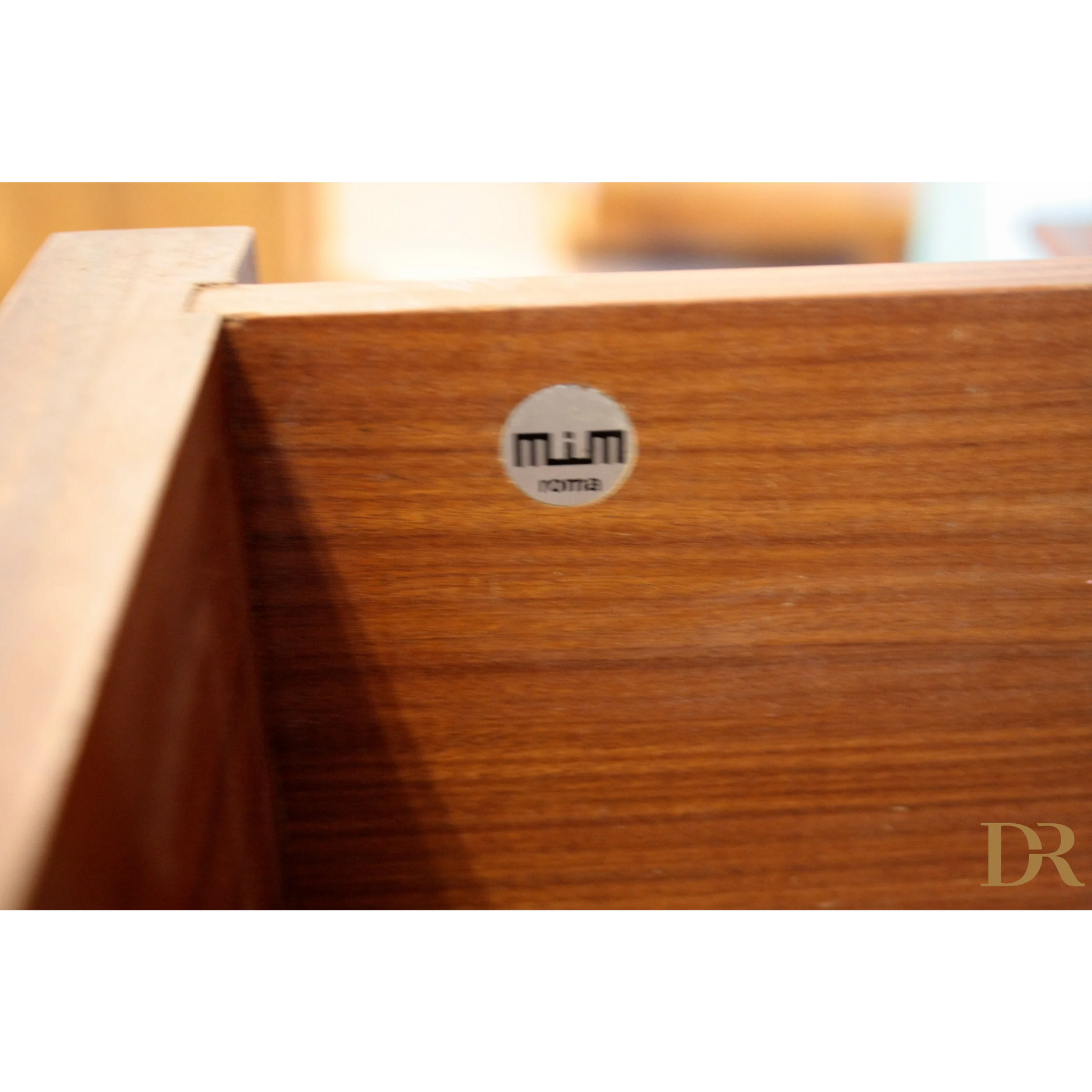 Dettaglio drawer in legno con adesivo del produttore su parete modulare Urio di Luisa Parisi